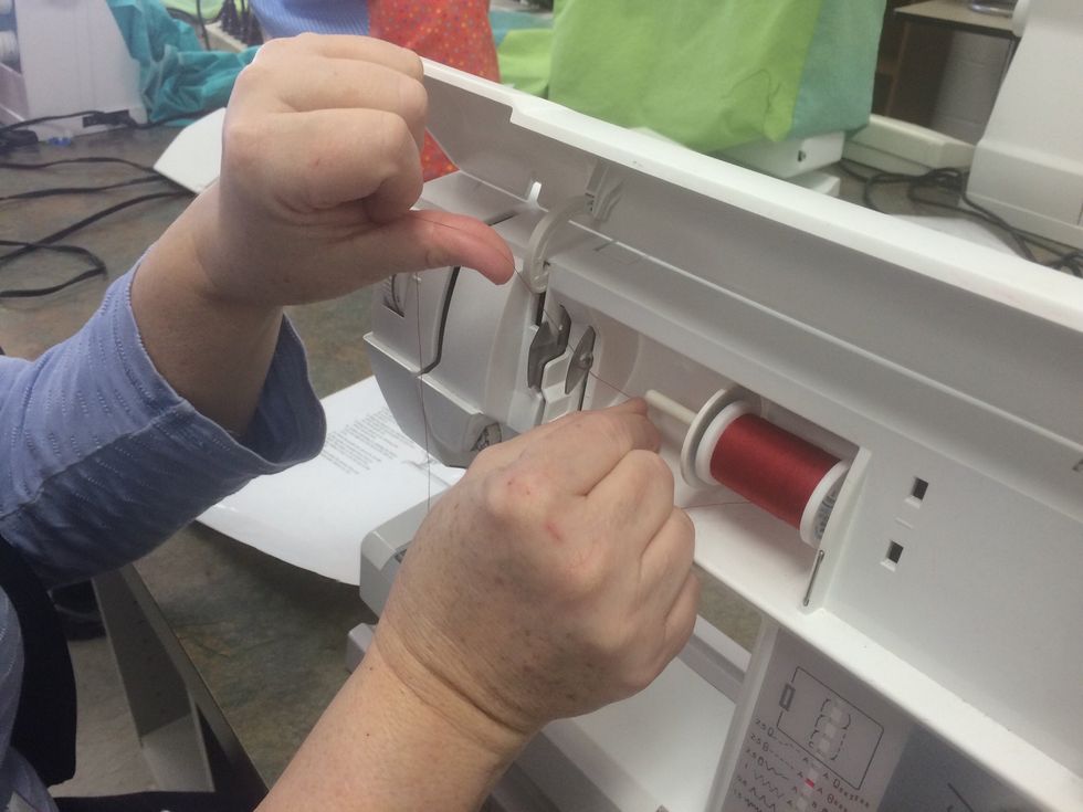 Guide the thread under the first thread guide and over the second thread guide