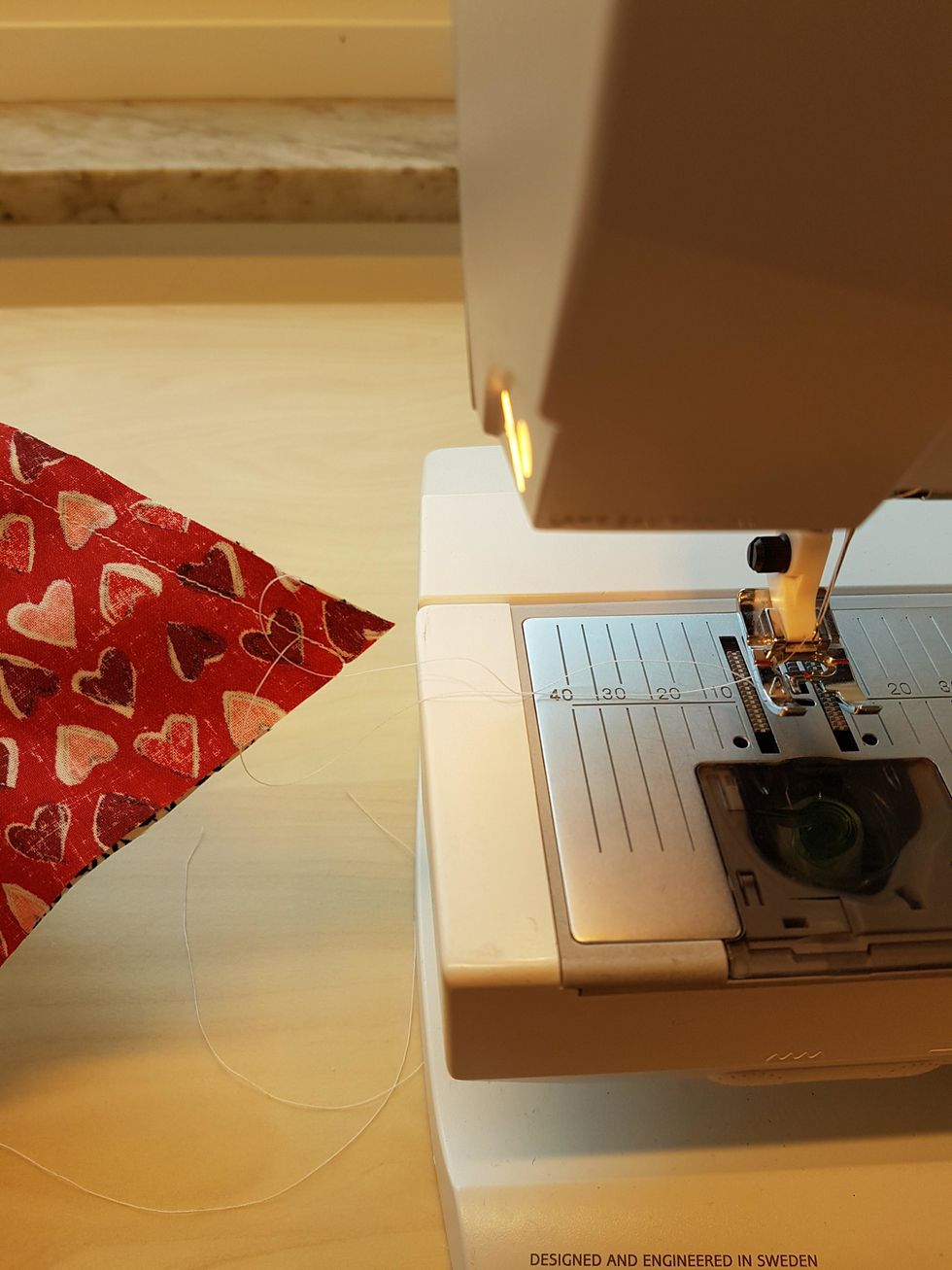 H\u00f6g pressarfoten och dra ut arbetet ur maskinen. Klipp av tr\u00e5darna.