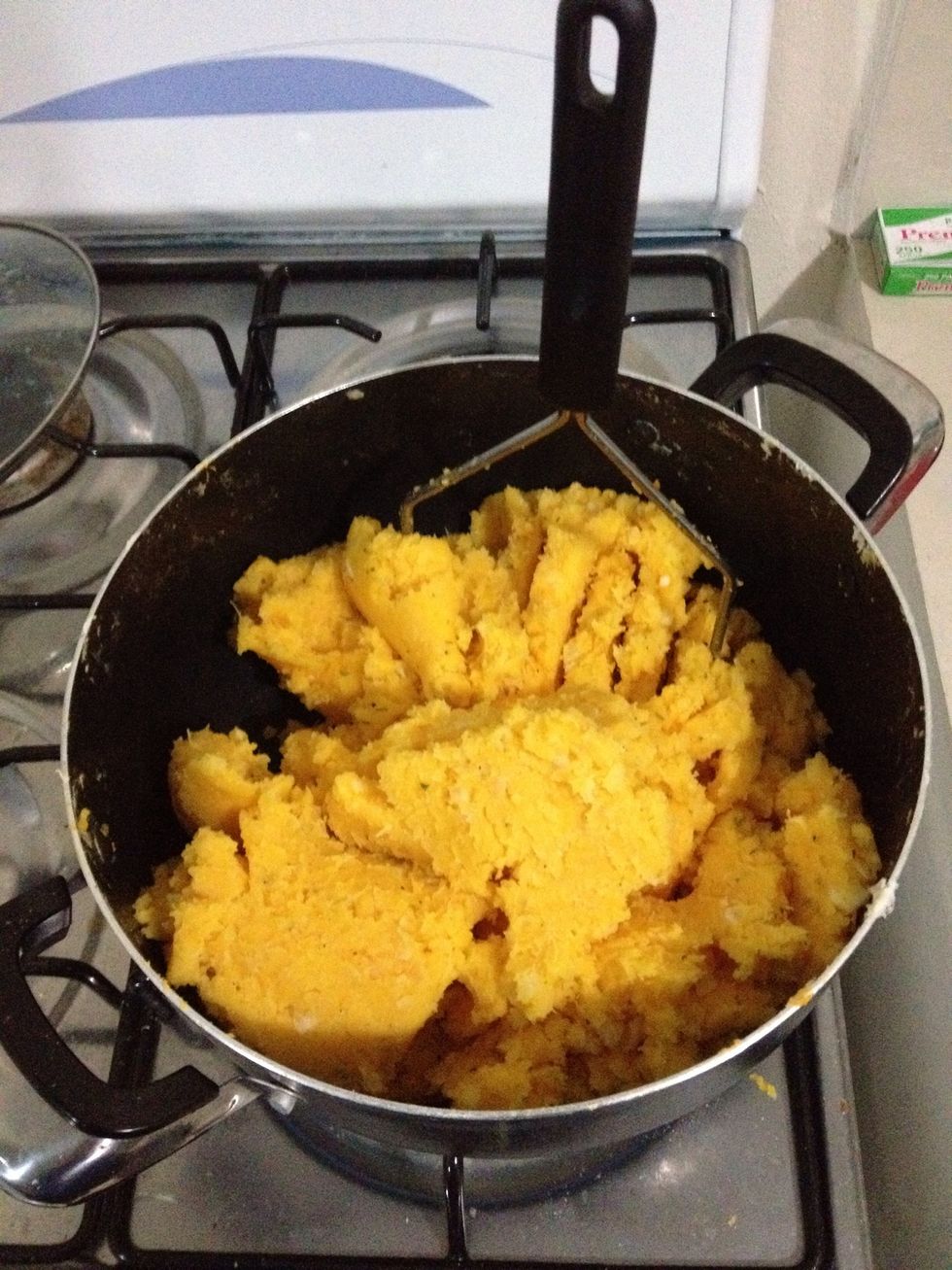 Hacer un pur\u00e9 de yuca con mantequilla, natilla, consom\u00e9 de pollo, achiote, sal, pimienta y romero.