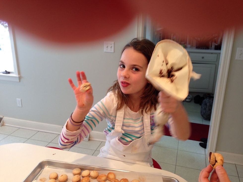 Hadley is demonstrating what to do with a broken cookie. If this were a video, you'd see her pop it in her mouth. Very efficient .