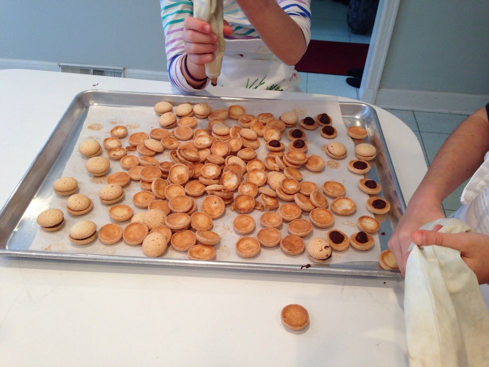Hadley is killing it with the pastry bag! This would be the perfect place to insert a video. But no. She and Hildegard finish filling these in no time. Check the chocolate on the stove.