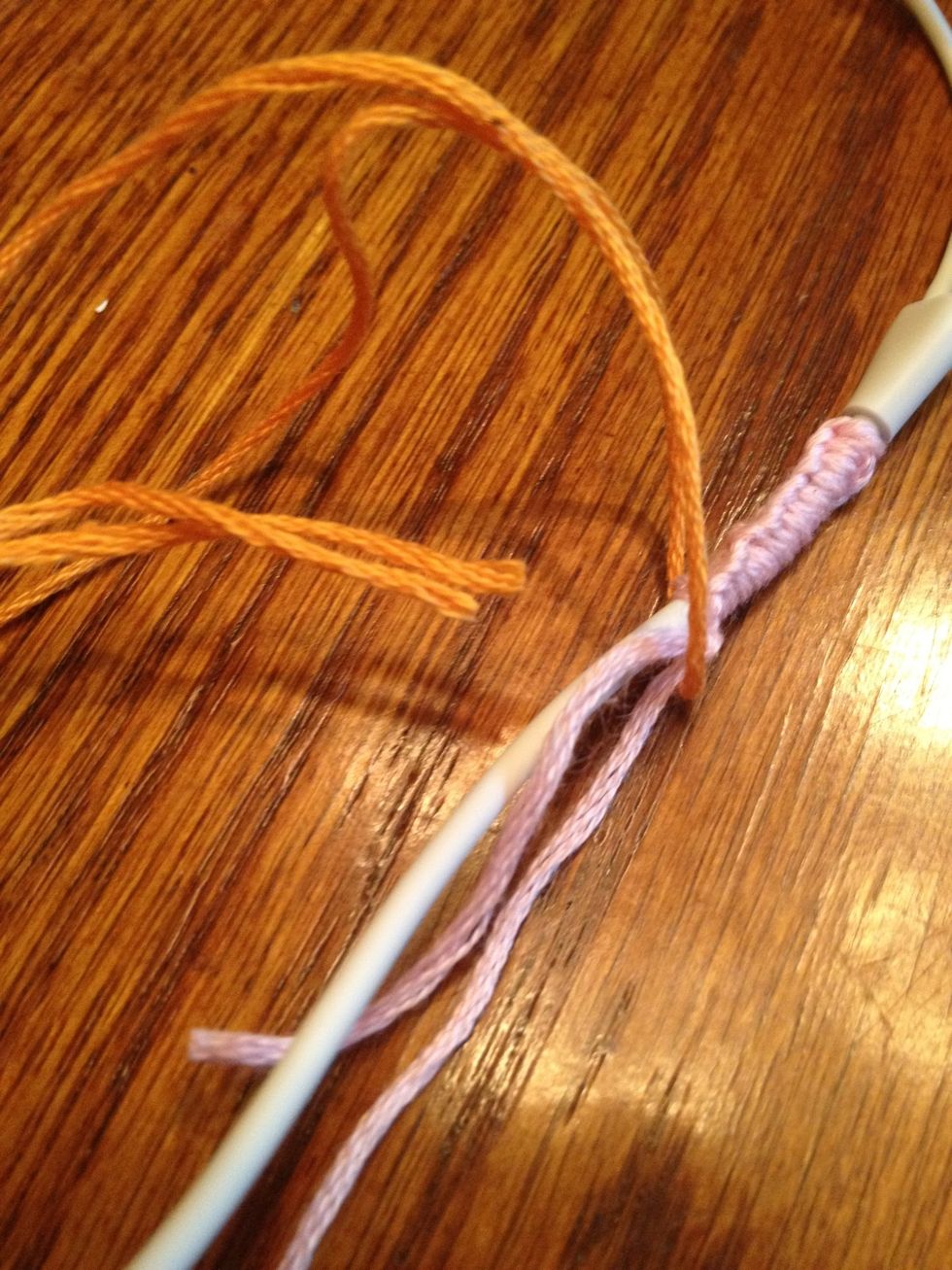 Half the second color over the cord and strings from the first color