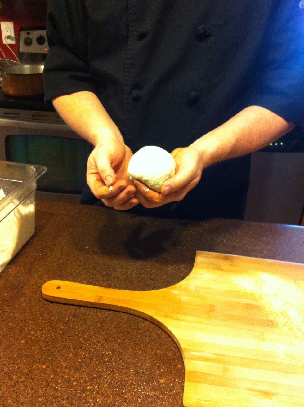 Handling the dough as little as possible, quickly shape it into a loaf by gently stretching the sides apart and tucking the flaps underneath, making a smooth surface on top.