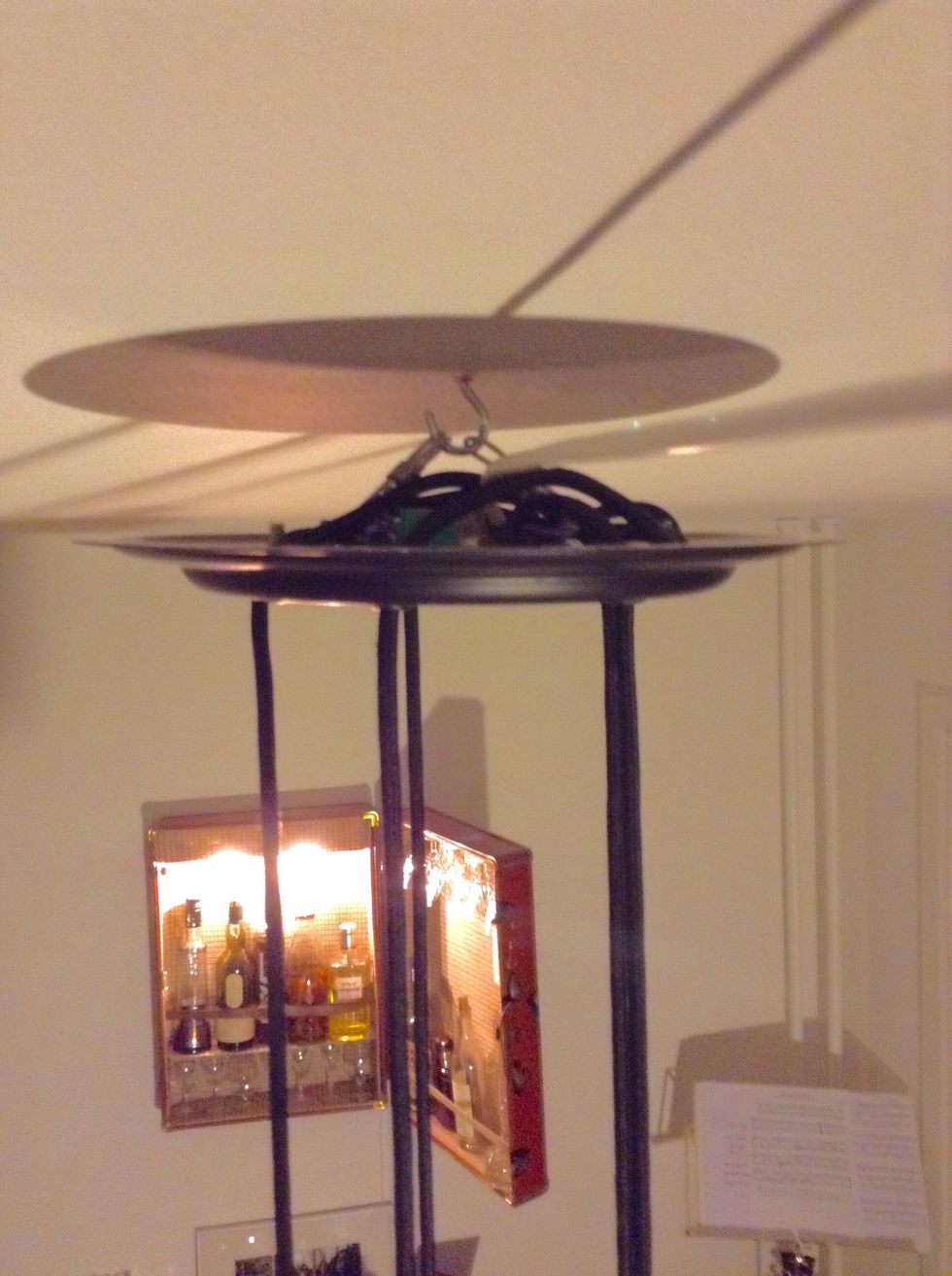 Hang it from the ceiling. Adjust the length of the cords so the bottles look harmonic