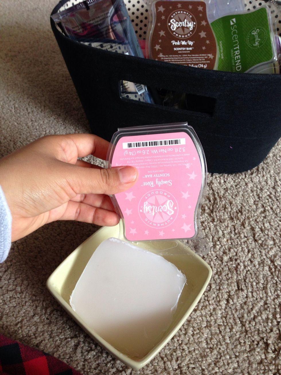 Having gone around the wax, use the edge of the plastic box to dig under the wax to pop it out.