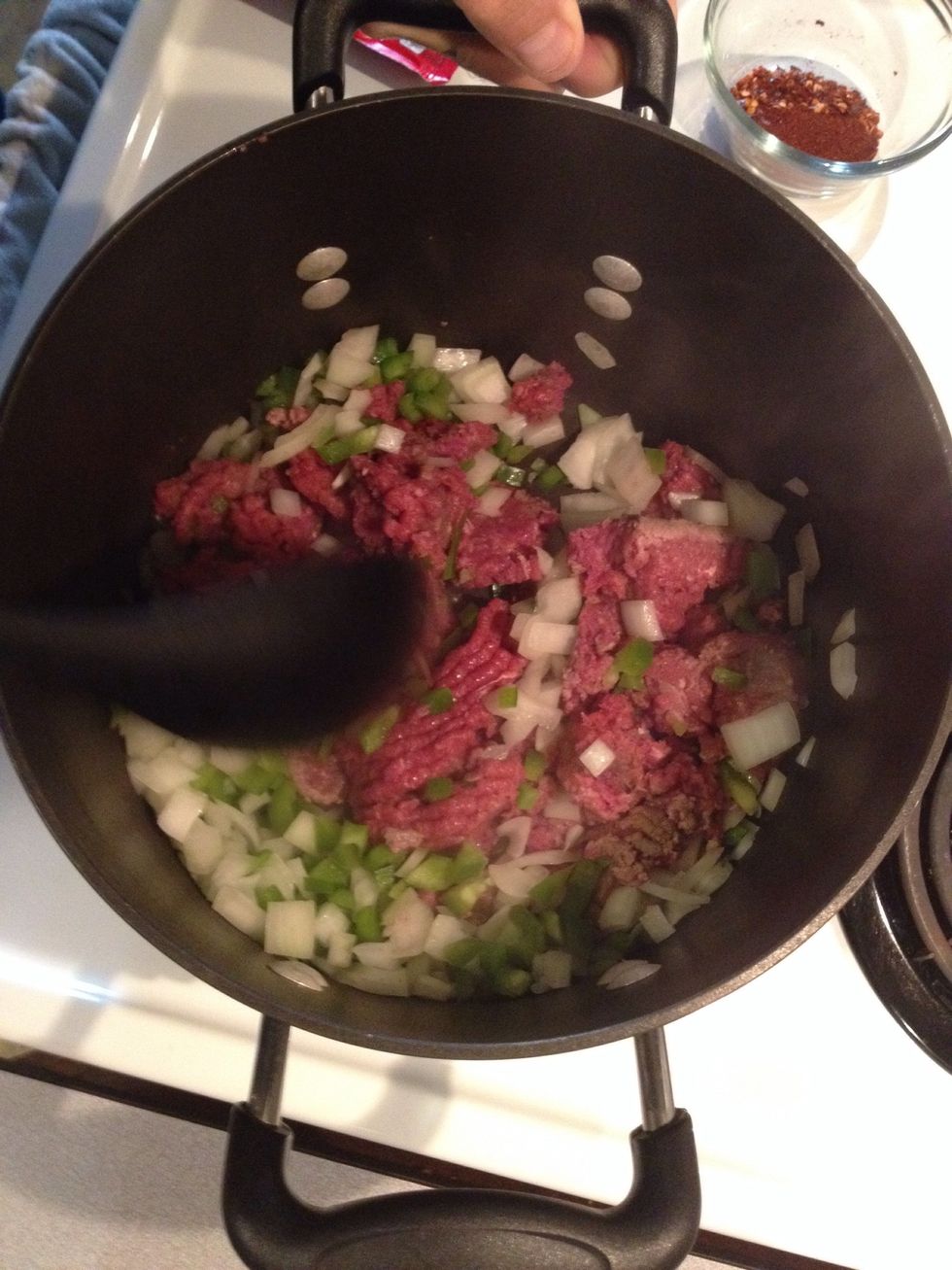 Hear peppers, onions and ground beef in a large pot over medium heat until meat is thoroughly cooked.