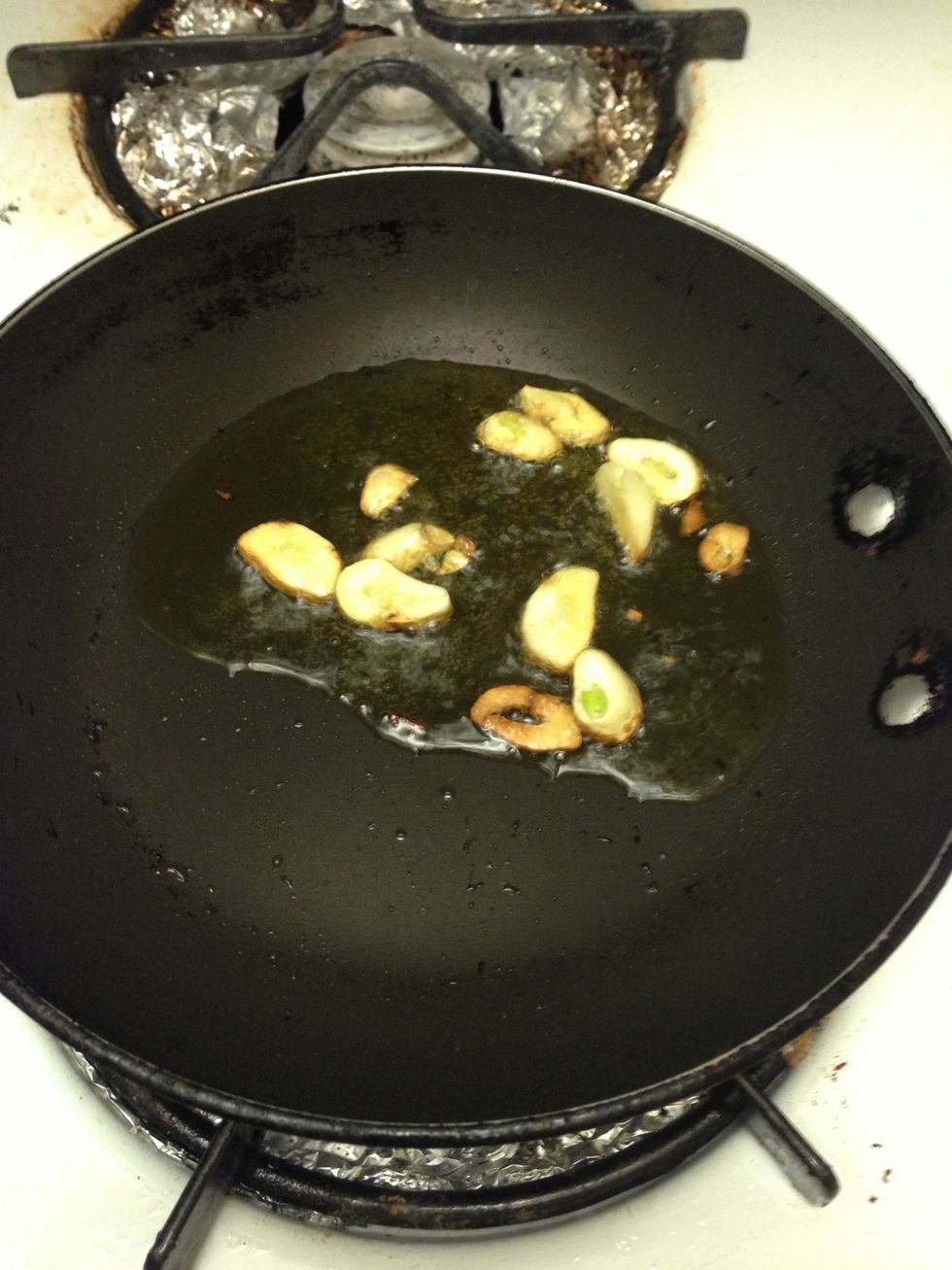 Heat 2 tbsp of olive oil over med-high heat. Saut\u00e9 garlic until it starts to brown, should take about 1-2 min. Reduce to low heat and add 3 cups of red wine.