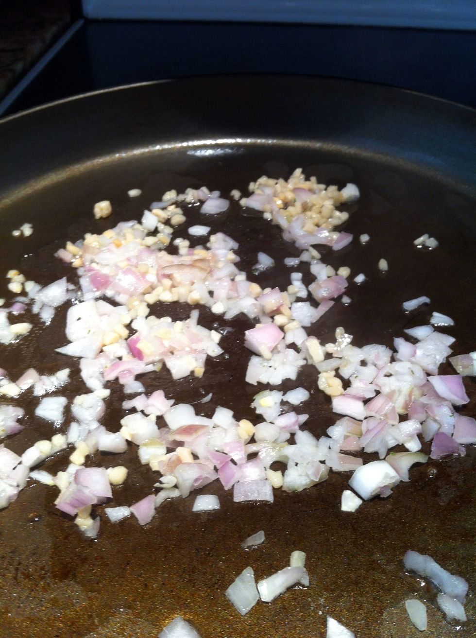 Heat a large skillet over medium high heat. Add olive oil, shallot, and garlic. Saute for 3 - 5 minutes to lightly brown and soften. Add wine, lemon juice and clams.