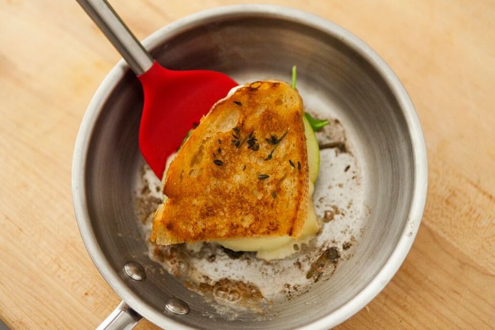 Heat a skillet over medium-low heat. Place sandwich in skillet, butter side down. Then, butter the other side of bread.