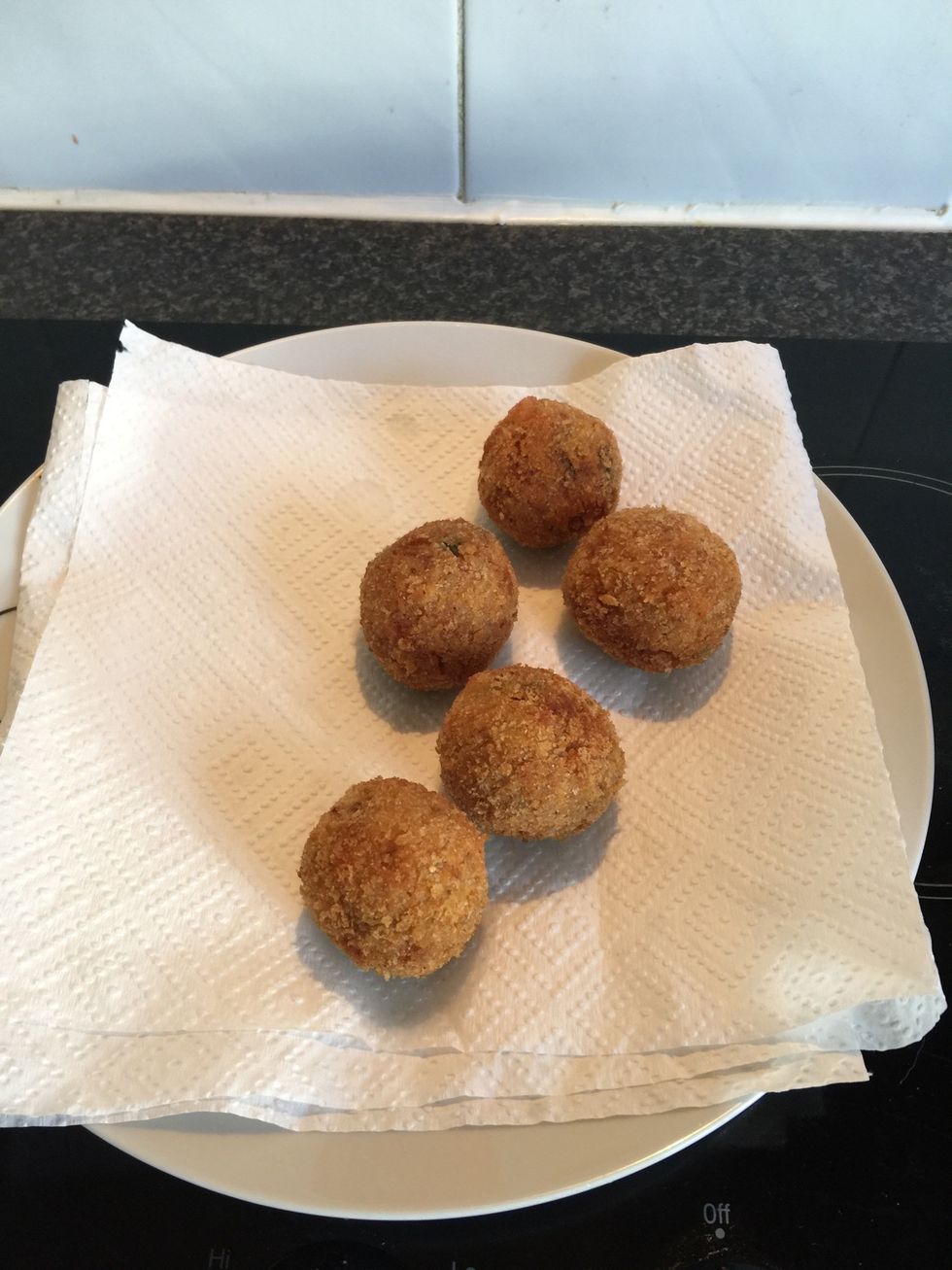 Heat enough oil in a pan to cover the arancini. When hot place a few in at a time but don't over crowd. Fry until golden.