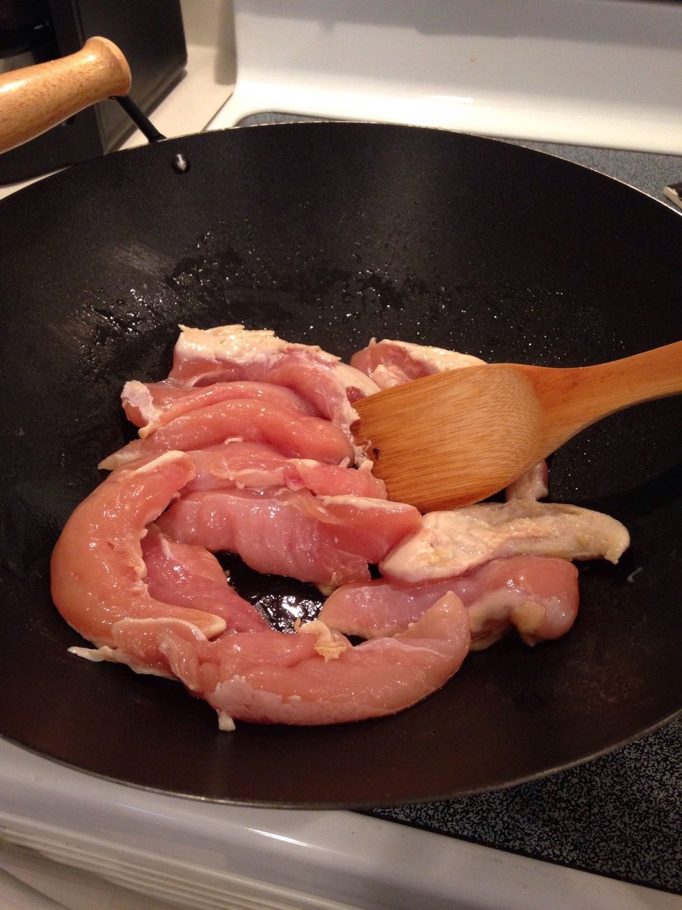 Heat oil in wok or large pan and add chicken.