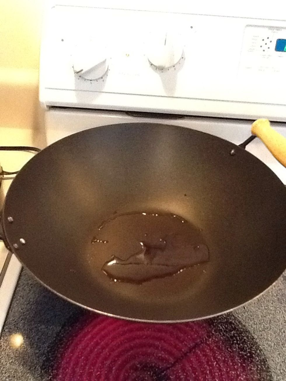Heat oil over medium heat in a wok or pan.