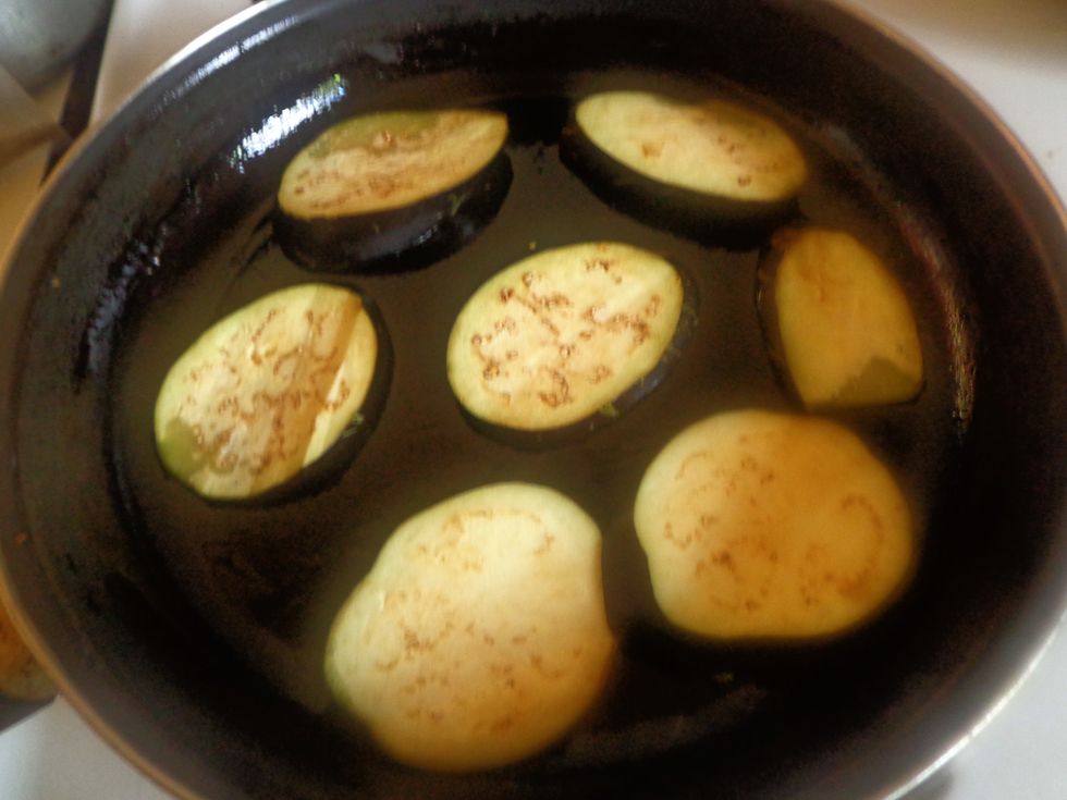 Heat oil/vegetable oil in a frying pan then cook the eggplant slices until golden brown on both sides.