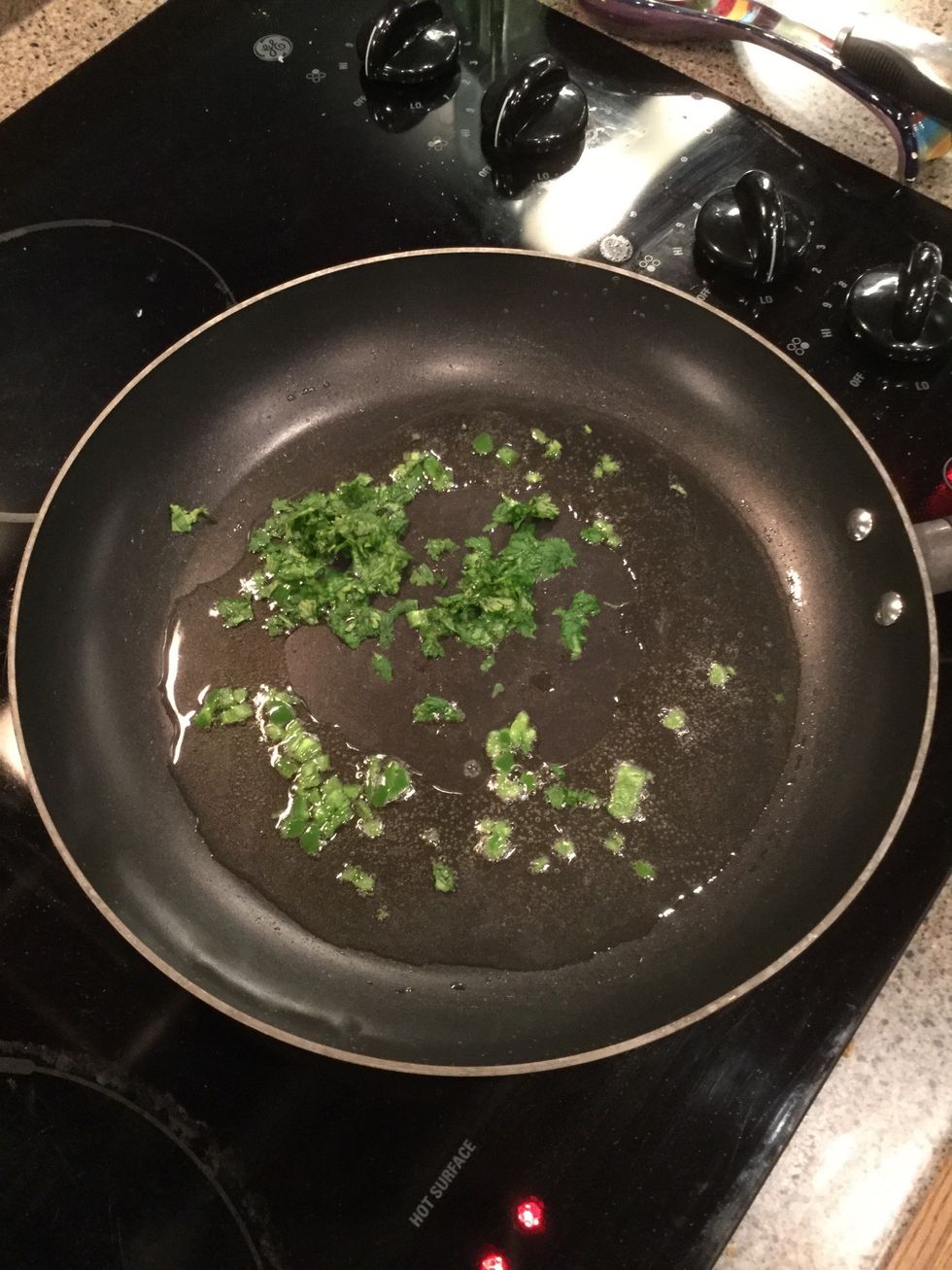 Heat olive oil in a medium skillet over medium heat. Stir in serrano pepper, cilantro, and cook until tender.