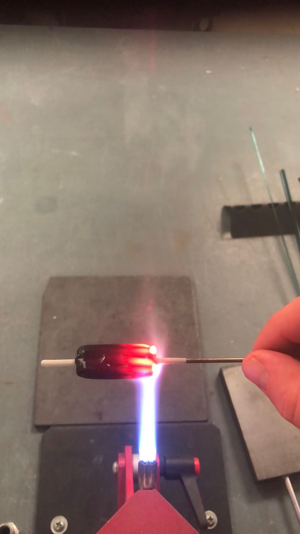 Heat one end while rotating the bead.