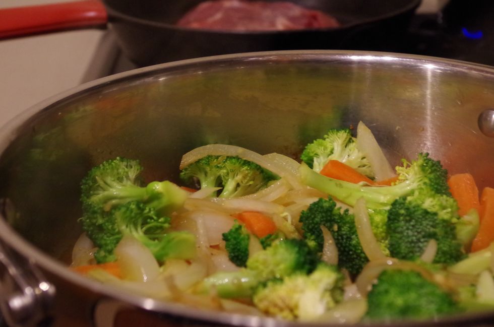 Heat sesame oil over medium heat and add 1 tbsp minced garlic, 1 tbsp grated ginger, 2 c broccoli florets, 1 c sliced carrots and 1 sliced onion. Saute for a few minutes.