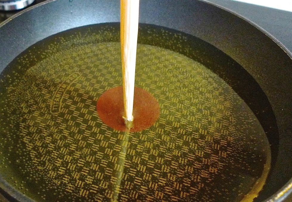 Heat some vegetable oil in a skillet or wok. Heat until oil is hot enough to fry the chicken. Small bubbles will appear at the bottom of the chopstick when ready.