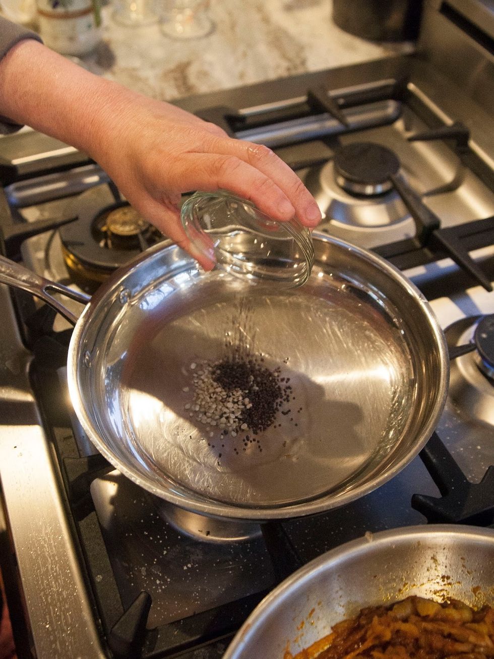 Heat the coconut oil in a saute pan or kadhai. When the oil is hot add in the mustard seeds and urad dal.