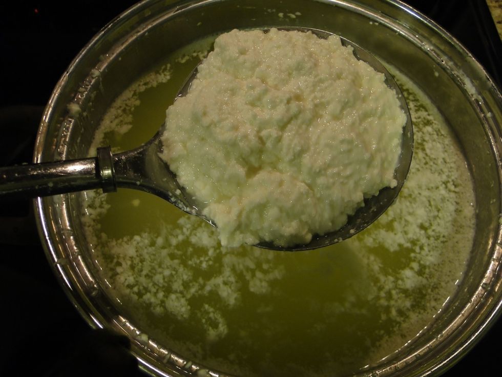 Heat the remaining liquid ( whey) to 185 deg Fahrenheit and place a workable amount of the solids on a slotted spoon and immerse it in the whey for about 60 seconds .