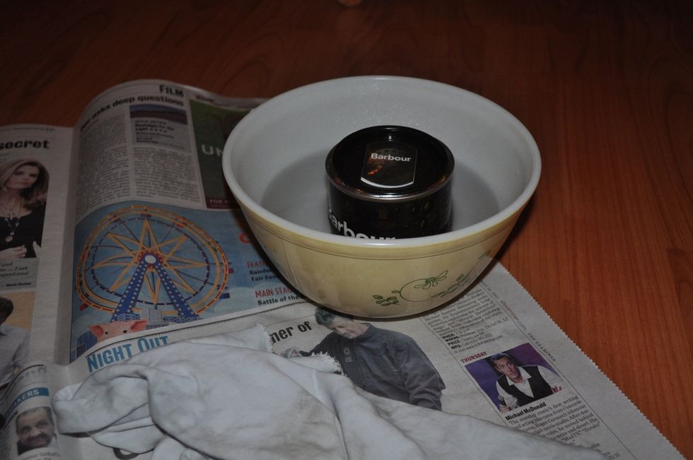 Heat the water in a tea kettle and pour into the bowl. Place the can of wax in hot water. To help trap heat and speed the melting of the wax, lightly cover it with the lid.