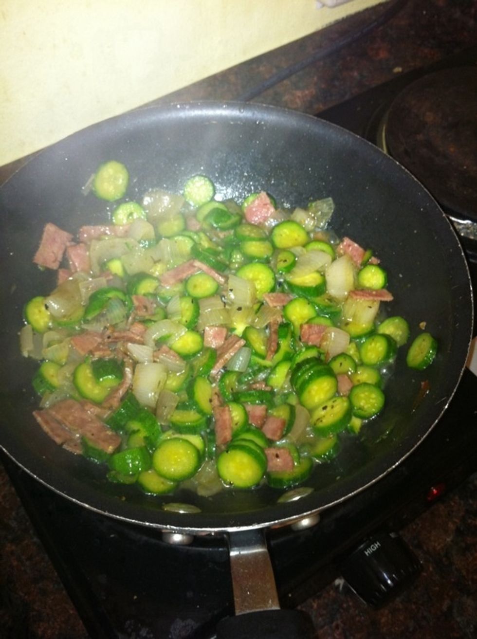 Heat up 2tbs of EV Olive oil in a frying pan, add the chopped scallions and turkey bacon. Let it fry for a minute and then add the zucchini and cook for another 5 minutes. Stir occasionally.