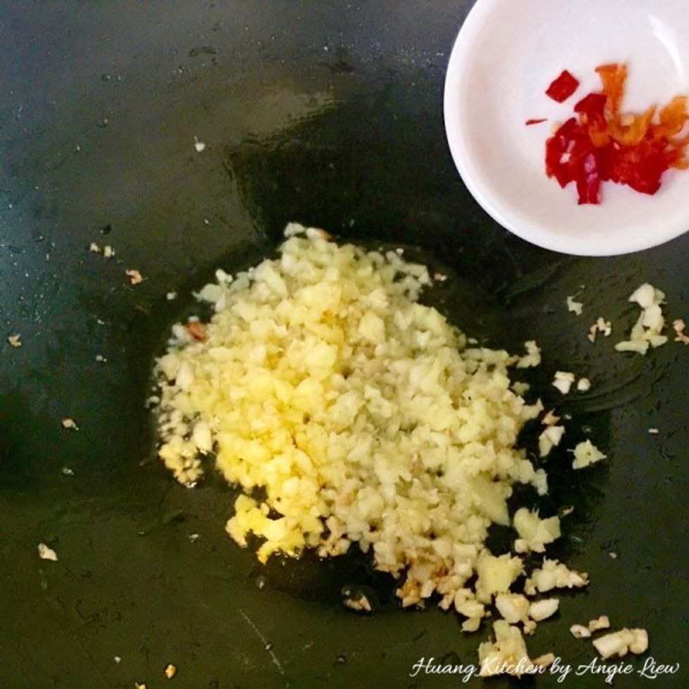 Heat up cooking oil in wok. Then add in chopped garlic, ginger and red chili. Stir fry over medium heat until fragrant and the garlic turns slightly golden brown.