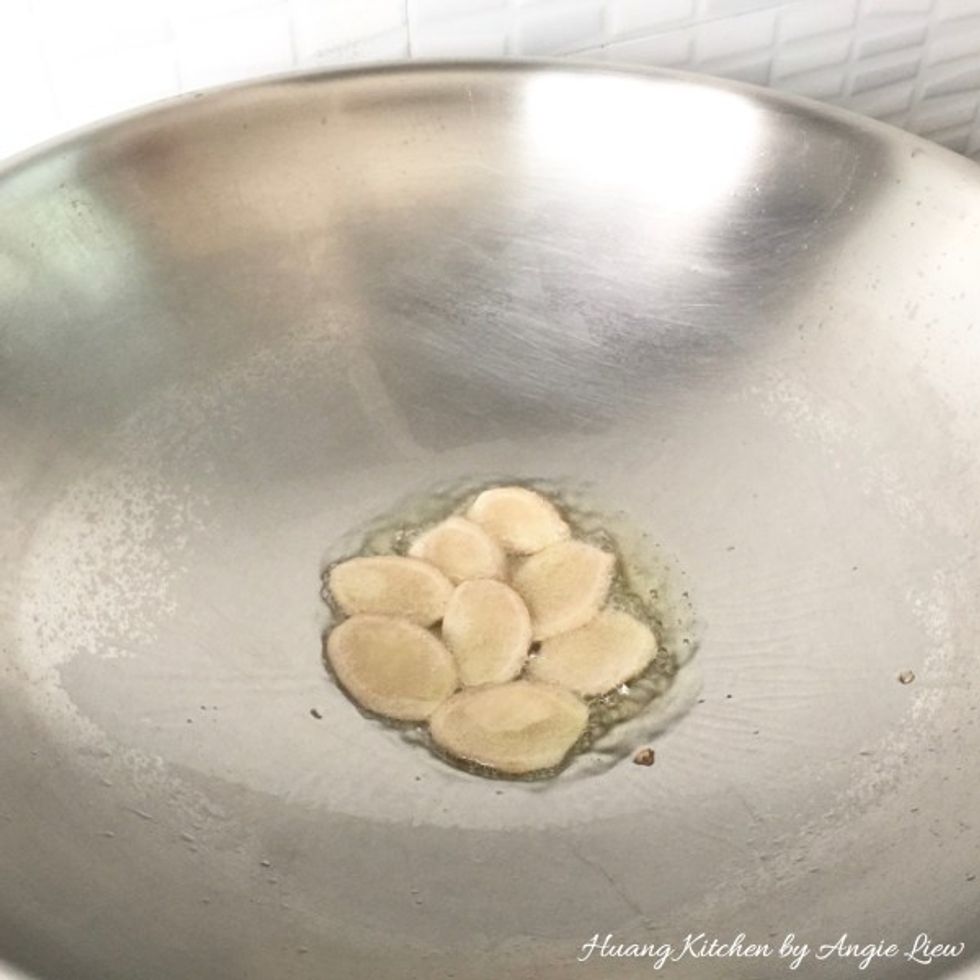 Heat up oil in a wok and saute the cut ginger slices.