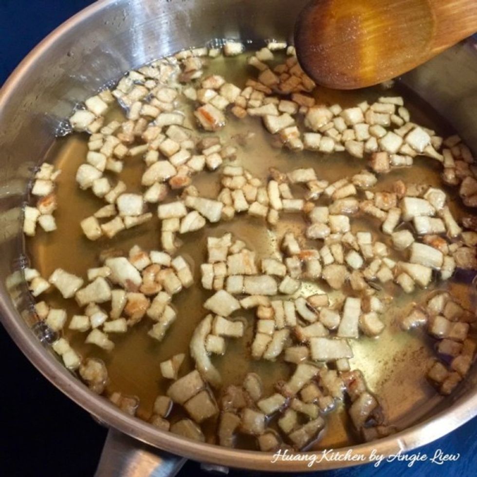 Heat up pork fats over low heat. Stir and flip the lard pieces in the sizzling oil until the lard pieces turn golden brown. Then filter to separate the lard pieces and oil. Set aside.