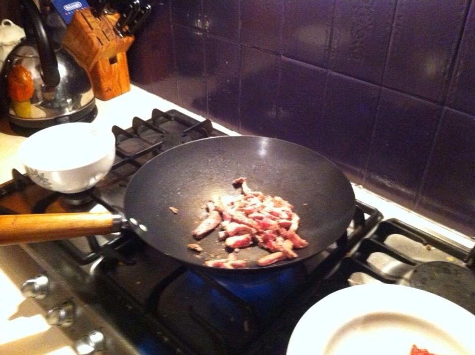 Heat up wok on very high flame Then add peanut oil and a drop of sesame The add half of the veal constantly stir until brown the take it out straight away do the same this with the other half