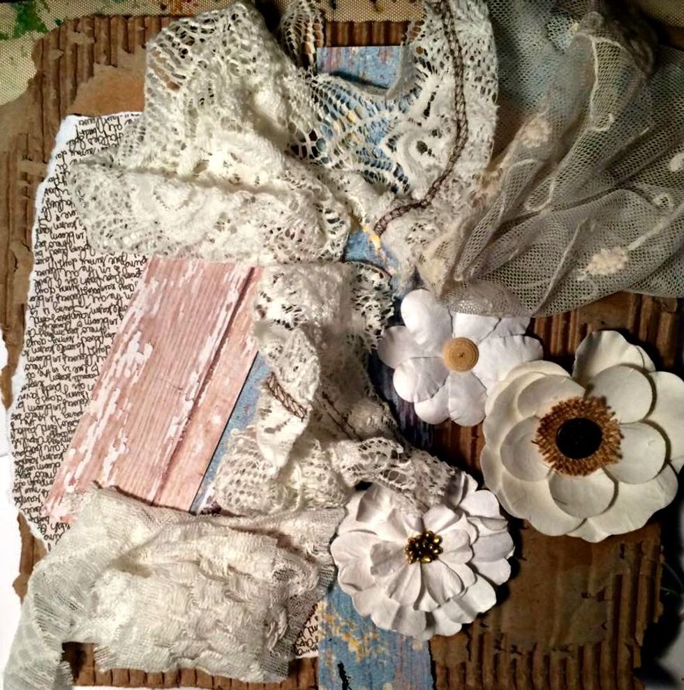Here are some of the other elements I gathered up. Some scrap paper, flowers, the lace. I'm going to sew all of these pieces to the corrugated cardboard. Not the flowers, just the paper, lace, fabric