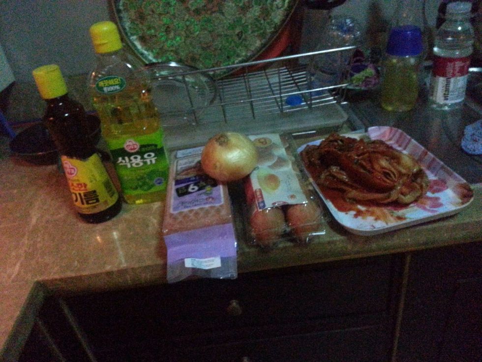Here are the ingredients - kimchi, egg, ham, onion, cooking oil (the one covered covered with the green thing), and a sesame oil (the one covered with the yellow thing).