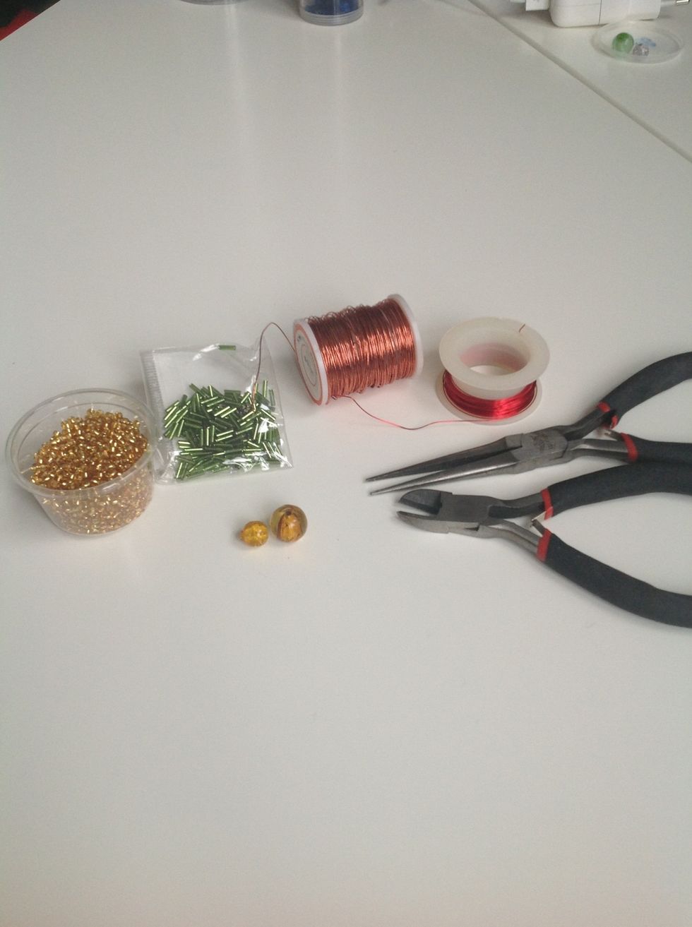 Here are the tools you need. First of all the two beads for the body, other tiny beads for the legs, two pliers and finally a wire. I prefer that you use a thicker wire. :)