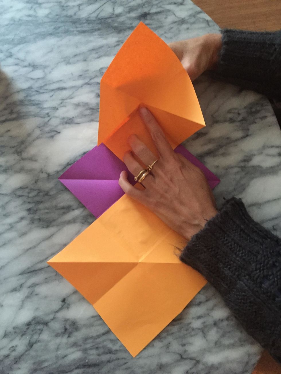 Here comes the squash fold!! Place one finger on the center of the folds and use your other hand to close the fold, kind of like making a puppet's mouth.