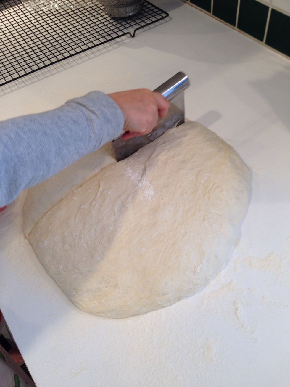 Here, Hildegard shows how to cut the dough into 3 equal pieces.