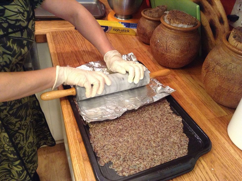 Here I'm trying to flatten it more evenly after pressing dough mix in with my hands. I'm using special nonstick foil, but you can use plastic wrap, wax paper, etc.