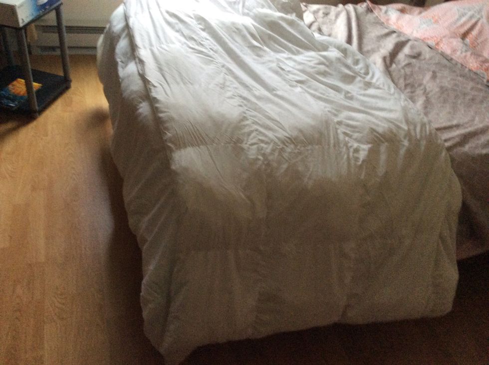 Here I take the blanket that will go into the duvet cover and folded it in half towards the bottom of the bed