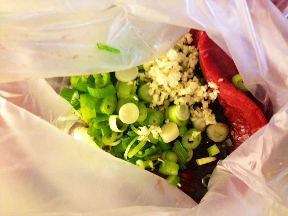 Here I've already poured the marinade in the bag. Then I've added the spring onions and the garlic.