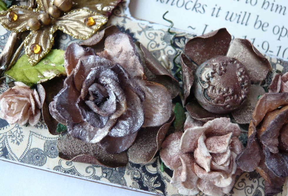 Here is a close-up view of some of the flowers and a meal button, all altered with paint and mica powder. (To alter the mulberry paper flowers, mist with water, then dust on Mica Powder. )