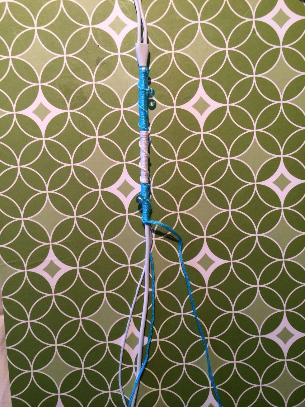 Here is a farther away picture to see how far along it is. Let's keep making knots and alternating colors and beads as you go along.