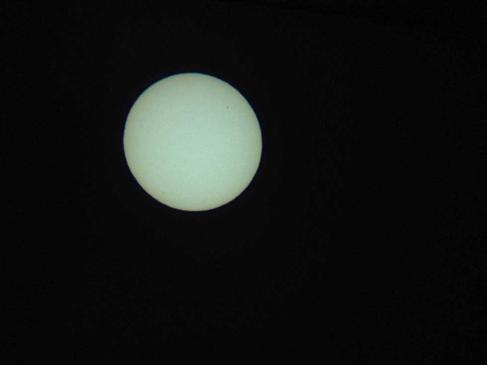 Here is an image I took of the sun just by sticking my iPhone in the box and snapping a picture. You can see a few sunspots.