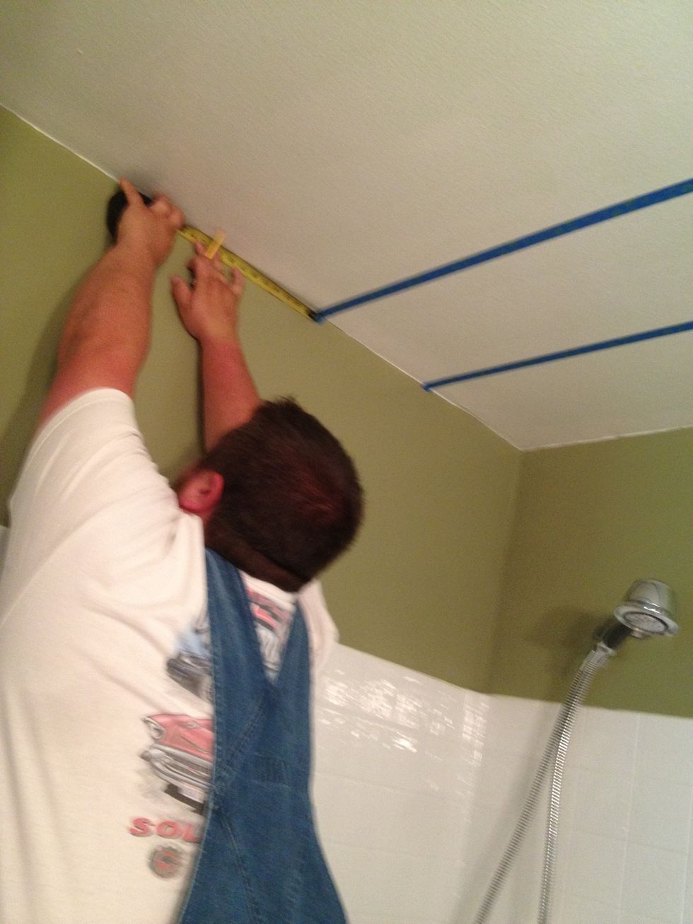 here is my sexy husband (yes, in overalls!!) he is doing a spectacular job measuring each stripe, marking with a pencil, and then we tape it together.