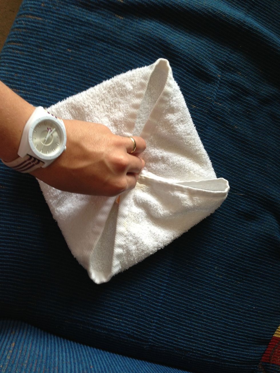 Here is the square formed. Now fasten the ends with your fingers from the center of the towel and turn upside down with the other hand....
