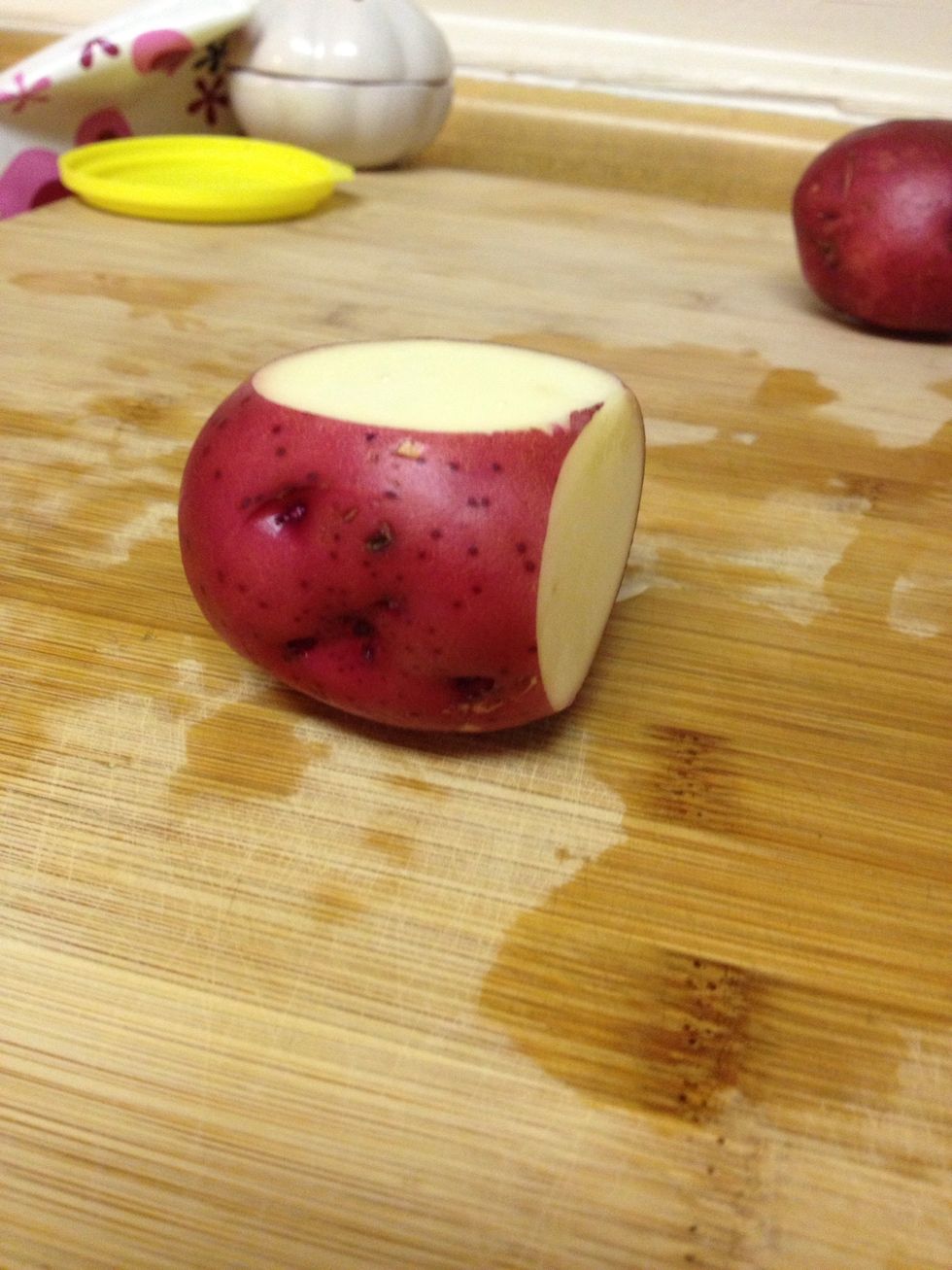 Here's a great tip for dicing round object like potatoes. First take a thin slice off of two sides. This will give you flat surfaces to stop the potato rolling around