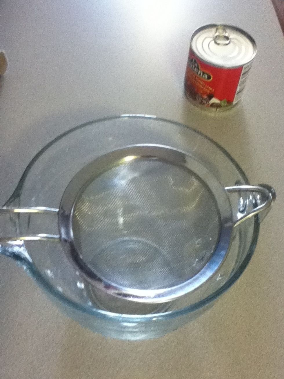 Here's a neat trick with a can of chipotle peppers. Set up a sieve over a bowl like so.