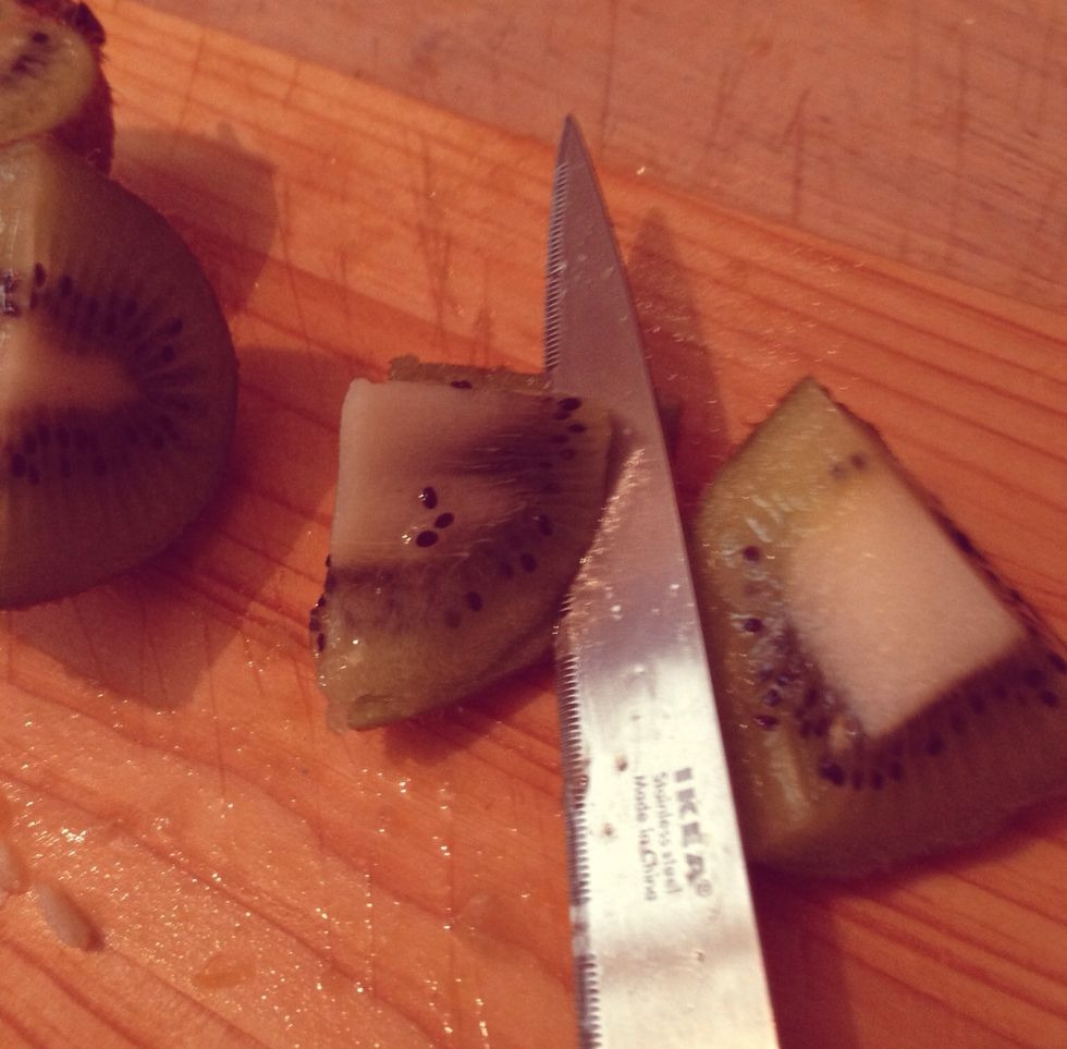 Here's a simple way to chop kiwi, no need to peel them first, just chop them into cubes, then with your knife cut from underneath it to remove the skin.