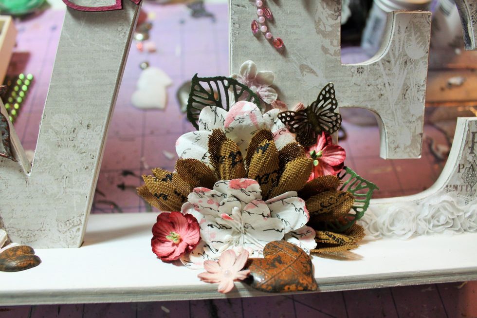 Here's a view of the "E" embellished with the flowers and a Prima metal butterfly. I hit the flowers with some Prima Glimmer Glaze in Pink Lady from my stash.