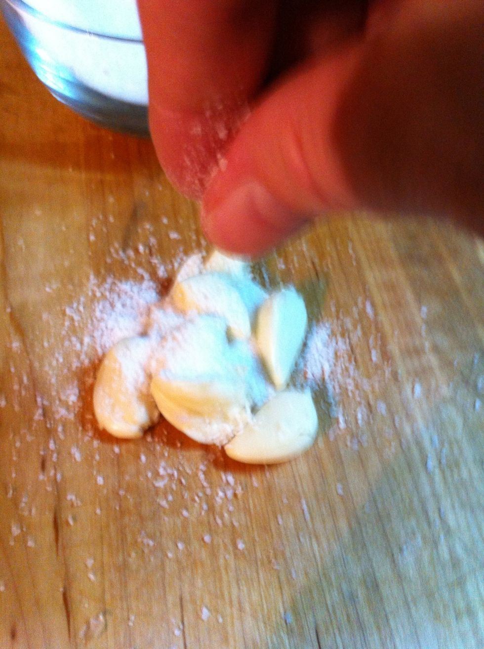 Here's the stack of cloves not chopped. Add liberal amount of salt on top. The salt gives the garlic a stronger taste.