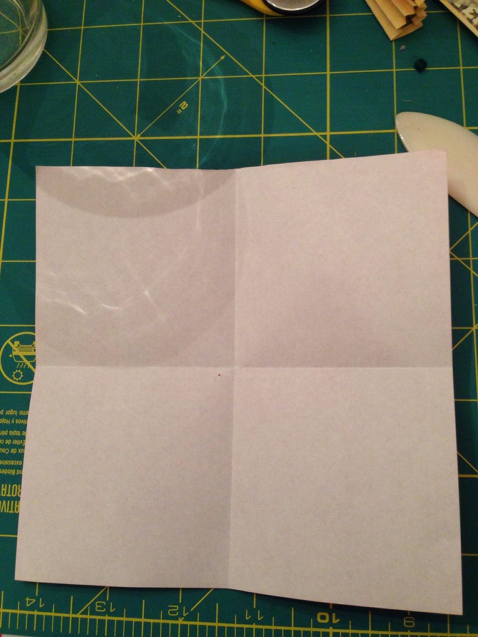 Here the paper is white side up and I have folded it in half horizontally and vertically. Now fold the top and bottom edges to the center crease.