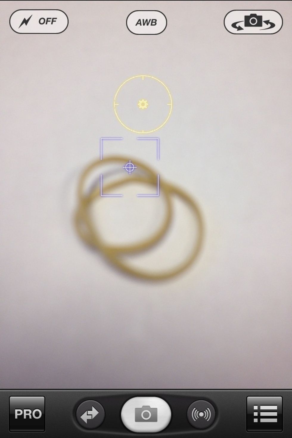 Here, the rubber band is out of focus (I have locked the focus on a far away object). We can make the iPhone focus by moving the SQUARE over the rubber band and releasing the icon.