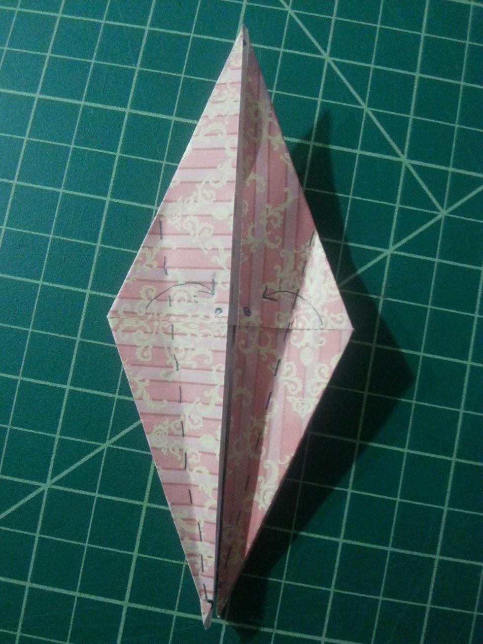 Here, we will do an ice cream fold along the dotted lines, each edge meeting the black dots in the center of the shape.